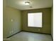 An empty bedroom with neutral paint, a window, a ceiling light, and vinyl flooring at 43241 W Kristal Ln, Maricopa, AZ 85138