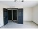 An airy bedroom featuring black doors, ceiling fan, and light gray flooring at 43241 W Kristal Ln, Maricopa, AZ 85138