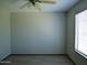 The bedroom has neutral walls, a ceiling fan, a window, and wood-look floors at 43241 W Kristal Ln, Maricopa, AZ 85138