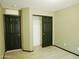 Empty bedroom with vinyl flooring, showing closet with sliding doors and entrance to ensuite at 43241 W Kristal Ln, Maricopa, AZ 85138