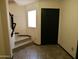 Welcoming entryway featuring tile flooring, a staircase with wood-look steps and black railing, and a black front door at 43241 W Kristal Ln, Maricopa, AZ 85138
