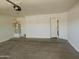 A clean garage featuring a water heater, smooth concrete floor, and a doorway leading inside the house at 43241 W Kristal Ln, Maricopa, AZ 85138