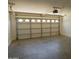 Spacious garage interior with a white door with windows, offering ample space for vehicles and storage at 43241 W Kristal Ln, Maricopa, AZ 85138
