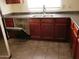 Kitchen featuring dark cabinetry, tile floor, and an open dishwasher at 43241 W Kristal Ln, Maricopa, AZ 85138