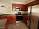 Kitchen view featuring stainless steel appliances, tile floor, and dark cabinets at 43241 W Kristal Ln, Maricopa, AZ 85138