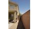 Exterior view of the side yard with gravel landscaping, a wooden gate, and access to backyard at 43241 W Kristal Ln, Maricopa, AZ 85138