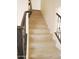 View of a staircase with wood-look steps and a black handrail, providing access to the upper level at 43241 W Kristal Ln, Maricopa, AZ 85138