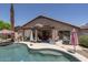 Backyard oasis with a pool, covered patio, lush plants, and lounge seating at 441 E Pinto Dr, Gilbert, AZ 85296