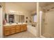 Bathroom featuring a double vanity, soaking tub, walk-in shower, and neutral color palette at 441 E Pinto Dr, Gilbert, AZ 85296