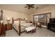 Cozy bedroom offers a patterned queen bed, lamps, and a view to the backyard at 441 E Pinto Dr, Gilbert, AZ 85296