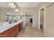 Spacious bathroom with double sinks, dark wood cabinets, and a separate toilet room at 44348 W Windrose Dr, Maricopa, AZ 85138