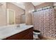 Cozy bathroom with a large mirror, vanity, and a shower with a patterned curtain at 44348 W Windrose Dr, Maricopa, AZ 85138