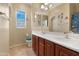 Well-lit bathroom featuring double sinks, dark wood cabinets, and Paw Patrol themed decor at 44348 W Windrose Dr, Maricopa, AZ 85138