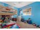bedroom with a bunk bed, bright blue walls, and playful decor at 44348 W Windrose Dr, Maricopa, AZ 85138