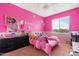 Bright bedroom with pink walls, plush toys on the bed, and a large window at 44348 W Windrose Dr, Maricopa, AZ 85138