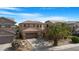 Exterior of a two-story home with a three-car garage and desert landscaping at 44348 W Windrose Dr, Maricopa, AZ 85138