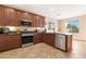 Modern kitchen featuring stainless steel appliances, dark cabinetry, and tile flooring at 44348 W Windrose Dr, Maricopa, AZ 85138