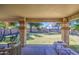 Inviting backyard with a covered patio, seating, picnic table, spacious lawn, trampoline, and mature trees at 4609 E Ironhorse Rd, Gilbert, AZ 85297