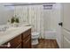 Cozy bathroom highlighting a single sink vanity, floral shower curtain, and modern fixtures with wood-look flooring at 4609 E Ironhorse Rd, Gilbert, AZ 85297