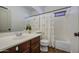 Bright bathroom featuring a single sink vanity, toilet, bathtub with curtain, and sleek fixtures at 4609 E Ironhorse Rd, Gilbert, AZ 85297
