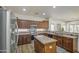 Well-lit kitchen features stainless steel appliances, custom cabinetry, granite countertops, and island with sink at 4609 E Ironhorse Rd, Gilbert, AZ 85297