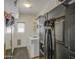 Functional laundry room with washer, dryer, black refrigerator, shelving, and a mirror at 4609 E Ironhorse Rd, Gilbert, AZ 85297