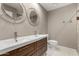 Bathroom featuring double sinks with modern wood vanity, contemporary mirrors, and neutral paint at 4939 E Paradise Dr, Scottsdale, AZ 85254