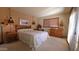 Cozy bedroom features wood furniture, neutral carpet and natural light at 5141 E Rancho Tierra Dr, Cave Creek, AZ 85331