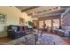 Bright living room with wood beam ceiling, brick accent wall, and comfortable furnishings at 5141 E Rancho Tierra Dr, Cave Creek, AZ 85331