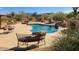 An inviting backyard pool surrounded by desert landscaping and lush greenery at 5141 E Rancho Tierra Dr, Cave Creek, AZ 85331