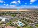 Expansive aerial view showcasing a community pool, palm trees, and mountain views in the distance at 683 W Honey Locust Ave, Queen Creek, AZ 85140