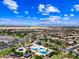 Expansive aerial view showcasing a community pool, palm trees, and mountain views in the distance at 683 W Honey Locust Ave, Queen Creek, AZ 85140