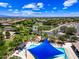 An elevated aerial view of a community pool area complete with blue sun shades and relaxing lounge chairs at 683 W Honey Locust Ave, Queen Creek, AZ 85140