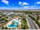 This aerial view showcases a community pool, with nearby buildings and a connecting road at 683 W Honey Locust Ave, Queen Creek, AZ 85140