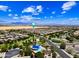 Expansive aerial view showcasing a community pool, palm trees, and mountain views in the distance at 683 W Honey Locust Ave, Queen Creek, AZ 85140