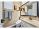 Cozy bathroom features a single sink vanity, toilet and a framed mirror over wood-look floors at 683 W Honey Locust Ave, Queen Creek, AZ 85140