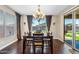 Dining room with a dark wood table, seating for six, large window with drapery and sliding glass door to the patio at 683 W Honey Locust Ave, Queen Creek, AZ 85140