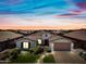 Beautiful single-Gathering home with manicured lawn, desert landscaping, and brick paver driveway, set against a colorful sky at 683 W Honey Locust Ave, Queen Creek, AZ 85140