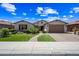 Charming single-story home with a well-manicured lawn, desert landscaping, and a brick driveway at 683 W Honey Locust Ave, Queen Creek, AZ 85140