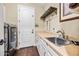 Practical laundry room featuring a sink, countertop, washer/dryer, storage cabinets, and backyard access door at 683 W Honey Locust Ave, Queen Creek, AZ 85140