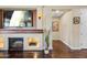Inviting living room featuring a fireplace with a television, sconces, and a glimpse into an adjacent hallway at 683 W Honey Locust Ave, Queen Creek, AZ 85140
