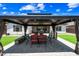 Under a pergola with dining table and chairs on a paved patio, surrounded by lush artificial turf and landscaping at 683 W Honey Locust Ave, Queen Creek, AZ 85140