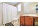 Bathroom with cherry cabinets, toilet, shower and a large mirror at 935 S Deerfield Ln, Gilbert, AZ 85296