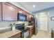 Kitchen featuring sleek black appliances, granite countertops, and dark wood cabinetry at 935 S Deerfield Ln, Gilbert, AZ 85296