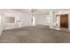 Open-concept living room featuring plush carpeting, elegant chandeliers, and access to other rooms at 9857 W Tonto Ln, Peoria, AZ 85382