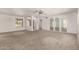 Spacious living room with neutral carpet, white walls, chandelier, and large windows that provide natural light at 9857 W Tonto Ln, Peoria, AZ 85382