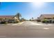 Neighborhood street view with well-maintained homes and palm trees under a clear blue sky at 9857 W Tonto Ln, Peoria, AZ 85382
