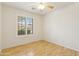 Bright bedroom features a ceiling fan and a window with plantation shutters at 10341 E Dragoon Ave, Mesa, AZ 85208