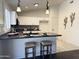 Stylish kitchen with pendant lights, barstool seating, dark countertops, and white cabinets at 10341 E Dragoon Ave, Mesa, AZ 85208