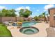 Backyard pool and spa feature rock waterfall, mature landscaping, and sunny patio at 10341 E Dragoon Ave, Mesa, AZ 85208